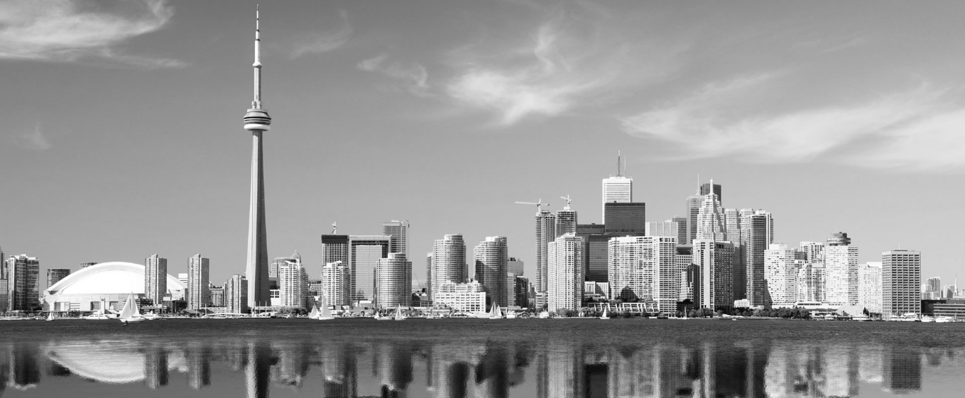 Black-and-white photograph of the Toronto skyline reflected in water.